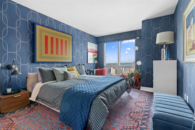 carpeted bedroom featuring wallpapered walls and baseboards