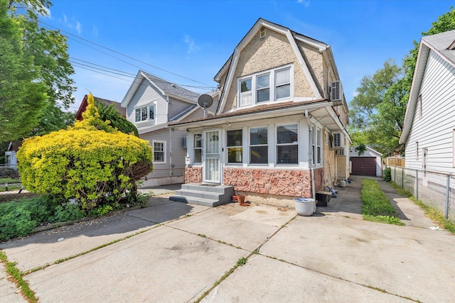 119-64 177th St, Saint Albans, NY 11434 - dutch colonial featuring fence, a gambrel roof, stone siding, a detached garage, and concrete driveway