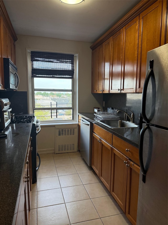 20 Wendell St Unit 9E, Hempstead, NY 11550 - kitchen with stainless steel appliances, light tile patterned floors, radiator heating unit, a sink, and brown cabinetry