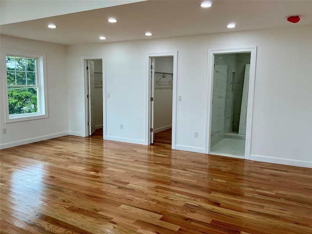 139 Miller Ave SW, Amityville, NY 11701 - unfurnished bedroom with a walk in closet, light wood-type flooring, recessed lighting, and baseboards