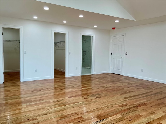 139 Miller Ave SW, Amityville, NY 11701 - unfurnished bedroom featuring a walk in closet, recessed lighting, light wood-type flooring, ensuite bathroom, and baseboards