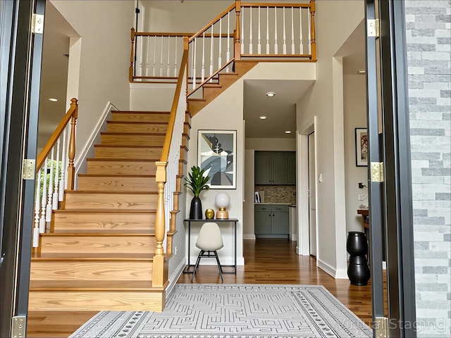 139 Miller Ave SW, Amityville, NY 11701 - entryway featuring wood finished floors, a towering ceiling, stairs, and baseboards