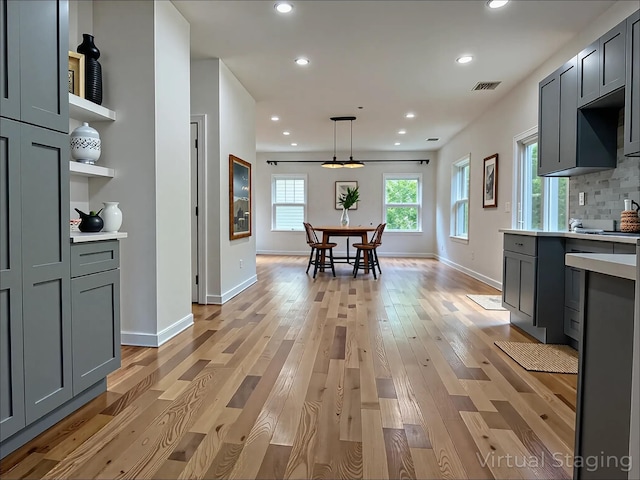 139 Miller Ave SW, Amityville, NY 11701 - kitchen with light wood-type flooring, light countertops, recessed lighting, baseboards, and decorative light fixtures
