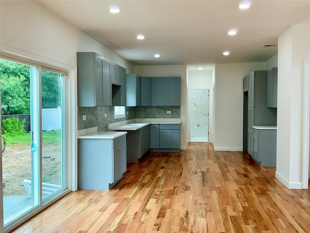 139 Miller Ave SW, Amityville, NY 11701 - kitchen with light wood-style floors, recessed lighting, tasteful backsplash, and gray cabinetry
