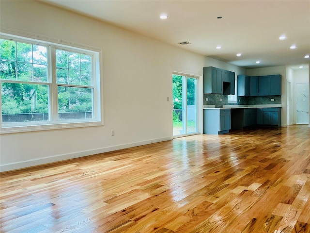 139 Miller Ave SW, Amityville, NY 11701 - unfurnished living room featuring light wood finished floors, healthy amount of natural light, baseboards, and recessed lighting
