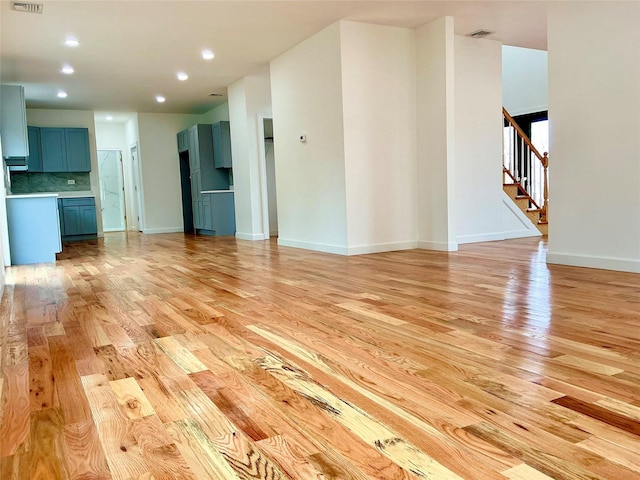 139 Miller Ave SW, Amityville, NY 11701 - unfurnished living room with light wood-style flooring, recessed lighting, stairway, and baseboards