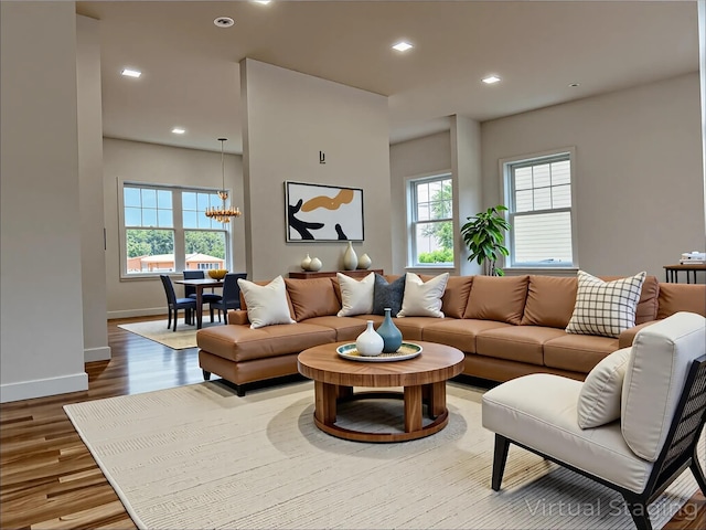 139 Miller Ave SW, Amityville, NY 11701 - living area featuring healthy amount of natural light, wood finished floors, baseboards, a chandelier, and recessed lighting