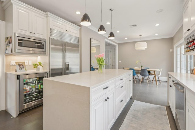 6 Murphy Ct, Blauvelt, NY 10913 - kitchen with built in appliances, wine cooler, white cabinets, a center island, and ornamental molding