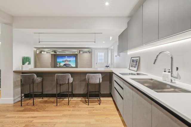 6 Murphy Ct, Blauvelt, NY 10913 - kitchen with a sink, modern cabinets, light wood-style floors, a kitchen bar, and light countertops