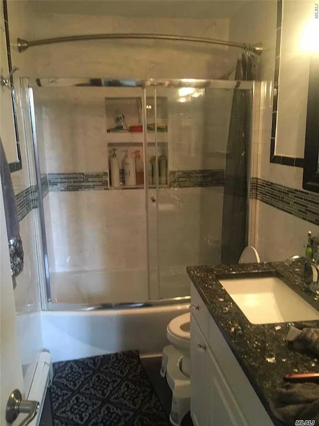 15 Oakhurst St, Huntington Station, NY 11746 - full bath featuring enclosed tub / shower combo, toilet, tile walls, and vanity