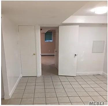 15 Oakhurst St, Huntington Station, NY 11746 - unfurnished room with baseboards and light tile patterned floors