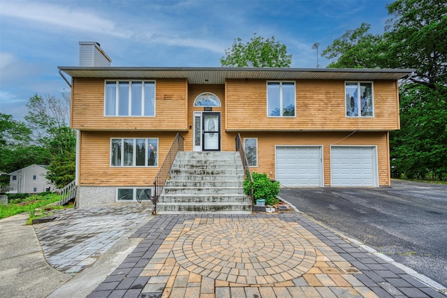 15 Oakhurst St, Huntington Station, NY 11746 - raised ranch with driveway, a garage, and a chimney