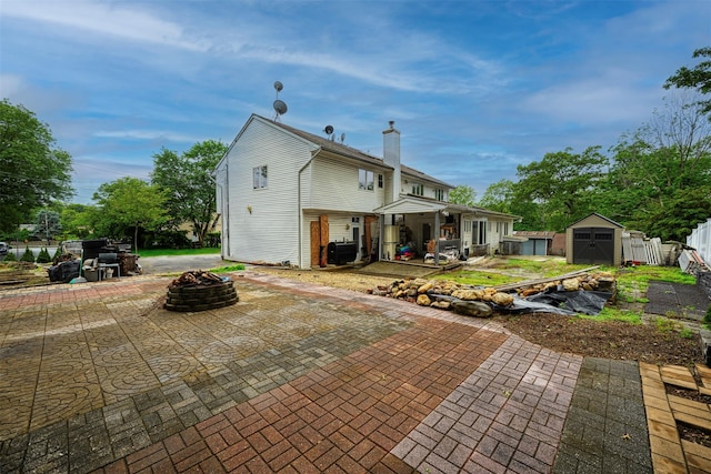 15 Oakhurst St, Huntington Station, NY 11746 - back of house with a fire pit, a patio area, and a storage unit