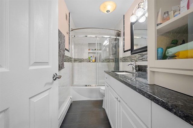 15 Oakhurst St, Huntington Station, NY 11746 - bathroom with baseboard heating, vanity, shower / bath combination with glass door, and decorative backsplash