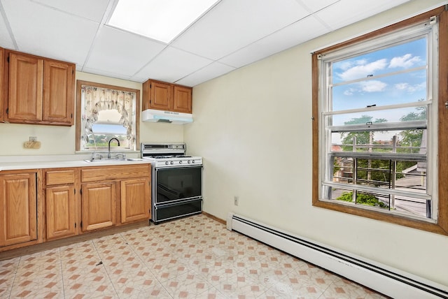 53 Howard St, Mount Vernon, NY 10550 - kitchen with gas range oven, baseboard heating, under cabinet range hood, a sink, and light countertops