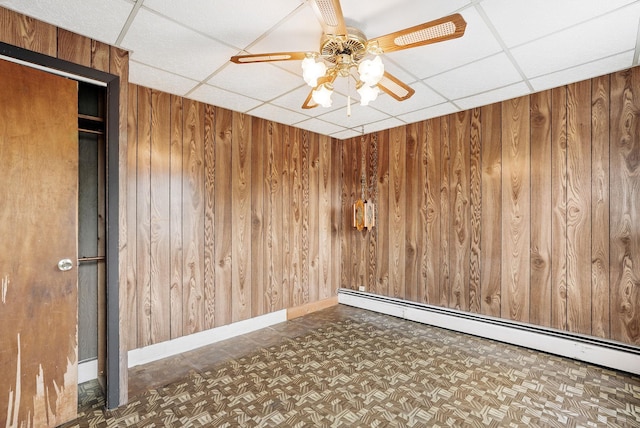 53 Howard St, Mount Vernon, NY 10550 - unfurnished room with a paneled ceiling, baseboard heating, wooden walls, ceiling fan, and baseboards