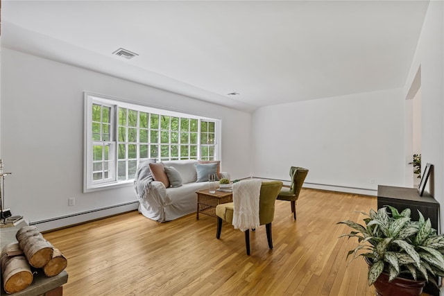 living room with baseboard heating and light wood-style flooring