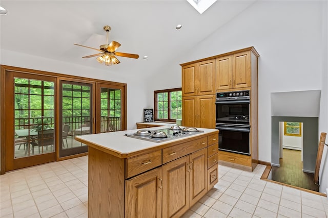 kitchen featuring stainless steel electric cooktop, light tile patterned floors, high vaulted ceiling, a kitchen island, and a ceiling fan