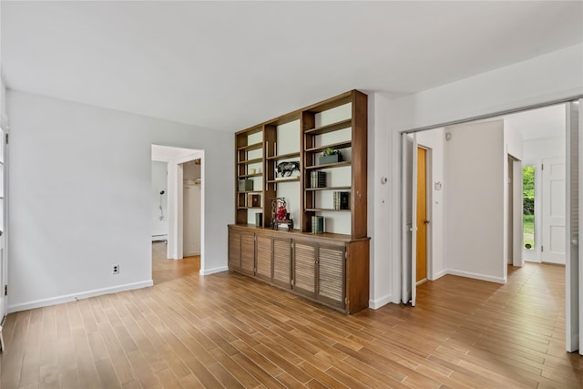 empty room featuring baseboards and light wood finished floors