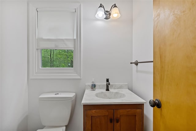 half bath featuring vanity and toilet