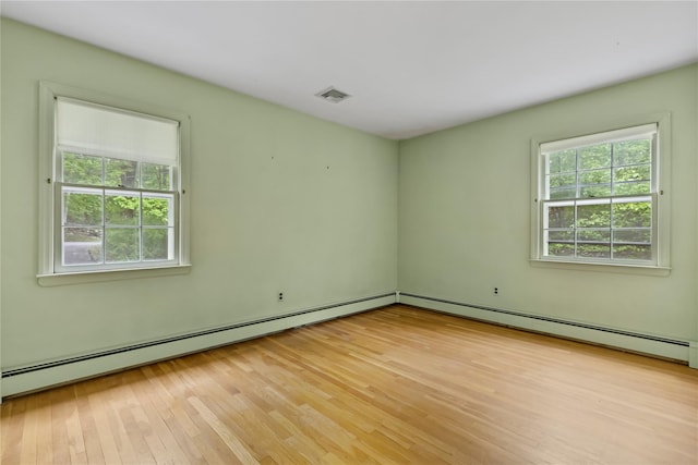 empty room with light wood-style floors and a baseboard radiator