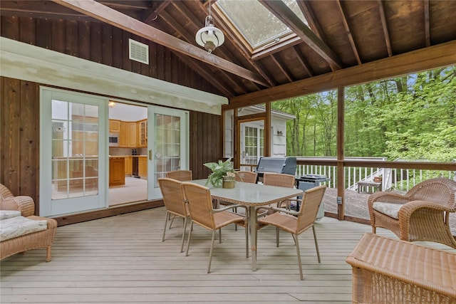 sunroom with outdoor dining space and a skylight