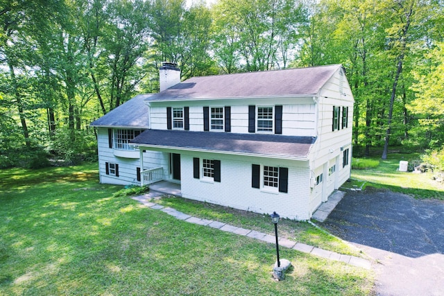 view of front facade featuring a chimney, roof with shingles, and a front lawn