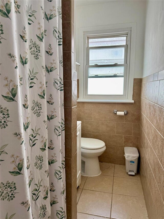 69-11 58th Rd, Maspeth, NY 11378 - full bath with toilet, tile patterned floors, tile walls, wainscoting, and a shower with shower curtain