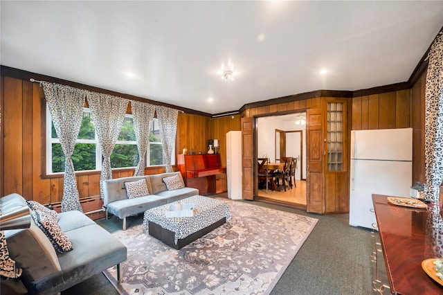 living room featuring ornamental molding, wood walls, and carpet flooring
