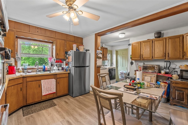 626 Union Ave, New Windsor, NY 12553 - kitchen featuring freestanding refrigerator, a sink, brown cabinetry, light countertops, and ornamental molding