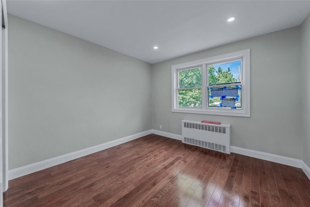 unfurnished room with radiator, baseboards, dark wood-style floors, and recessed lighting