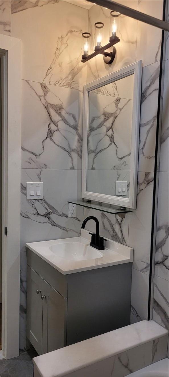 2925 Matthews Ave Unit 2H, Bronx, NY 10467 - bathroom with vanity, tile walls, and decorative backsplash