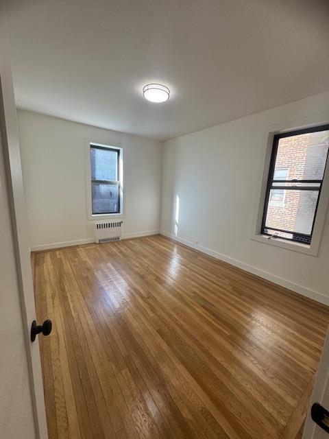 2925 Matthews Ave Unit 2H, Bronx, NY 10467 - unfurnished room with radiator, wood finished floors, and baseboards