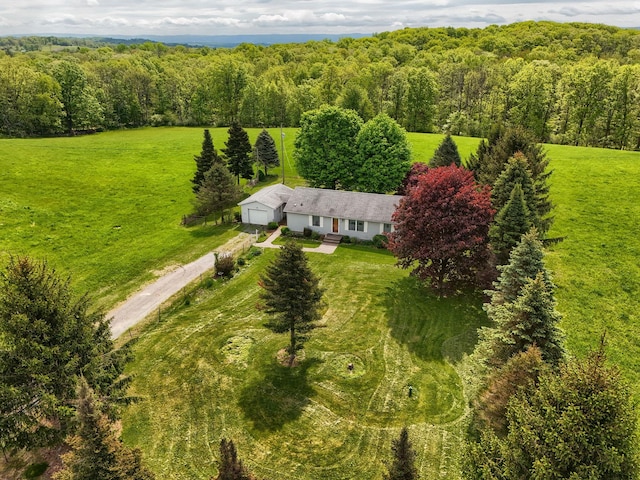 aerial view of property and surrounding area featuring a heavily wooded area