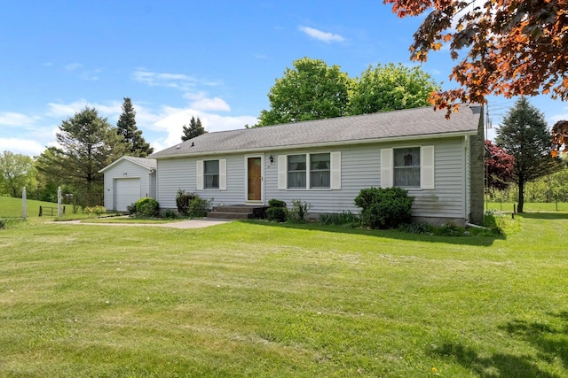view of front facade with an outbuilding, a front yard, and a detached garage
