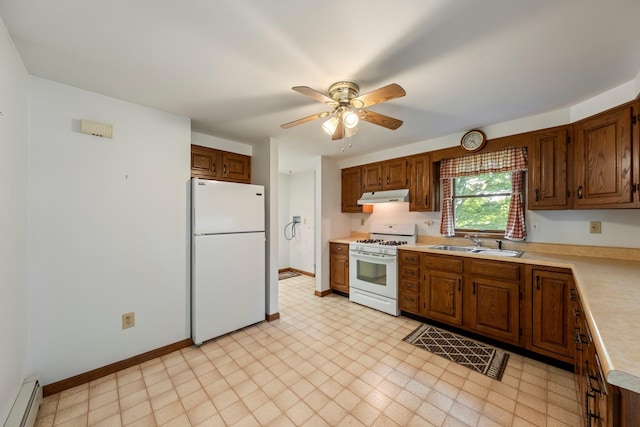 kitchen with white appliances, a baseboard heating unit, under cabinet range hood, a sink, and light countertops