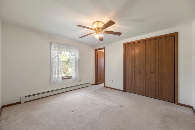 unfurnished bedroom with baseboard heating, light colored carpet, and a closet