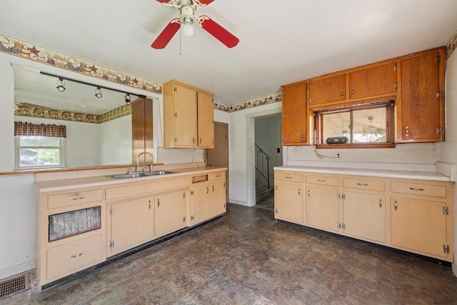 kitchen with a sink, light countertops, and a ceiling fan