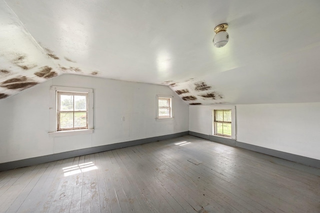 bonus room with lofted ceiling, wood-type flooring, and baseboards