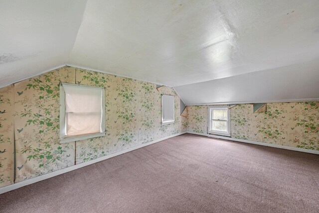 bonus room featuring vaulted ceiling, wallpapered walls, carpet floors, and baseboards