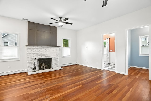 1755 Parmly Rd, Mohegan Lake, NY 10547 - unfurnished living room with ceiling fan, baseboard heating, wood finished floors, and a fireplace