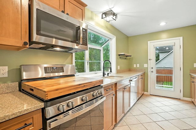 1755 Parmly Rd, Mohegan Lake, NY 10547 - kitchen featuring appliances with stainless steel finishes, light tile patterned flooring, light stone countertops, brown cabinetry, and recessed lighting