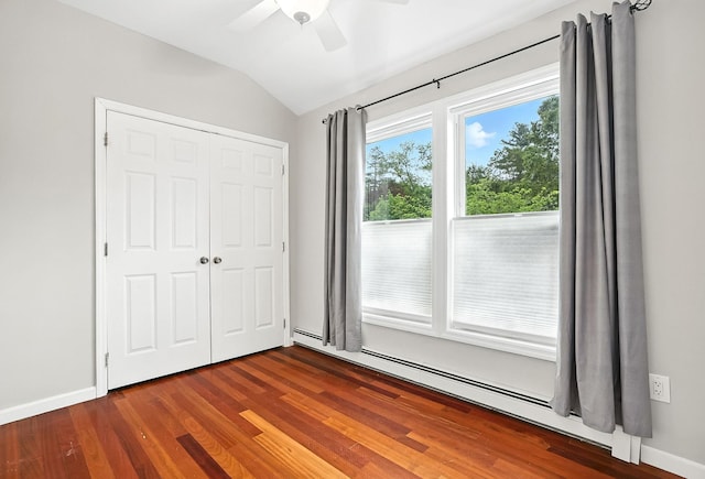 1755 Parmly Rd, Mohegan Lake, NY 10547 - unfurnished bedroom with baseboard heating, vaulted ceiling, a closet, wood finished floors, and a ceiling fan