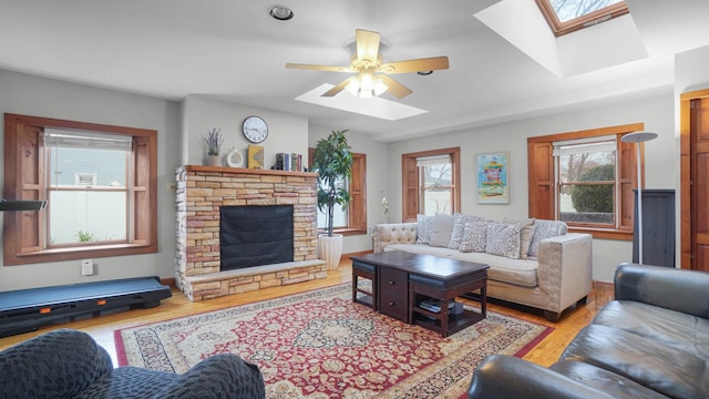 living area with a skylight, ceiling fan, and wood finished floors