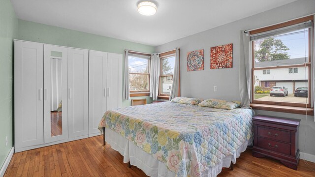 bedroom featuring wood finished floors, a closet, and baseboards