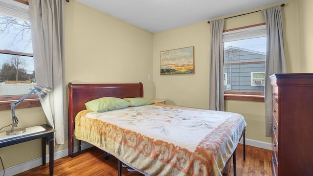 bedroom with wood finished floors and baseboards