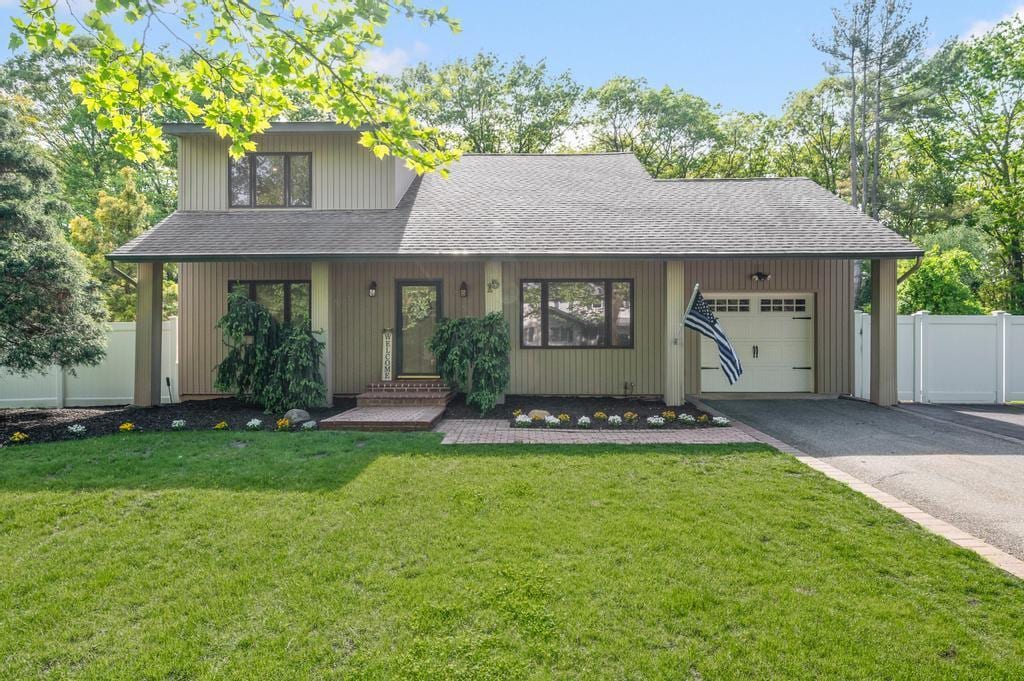 15 Patricia Ln, South Setauket, NY 11720 - view of front facade with a shingled roof, an attached garage, driveway, and entry steps