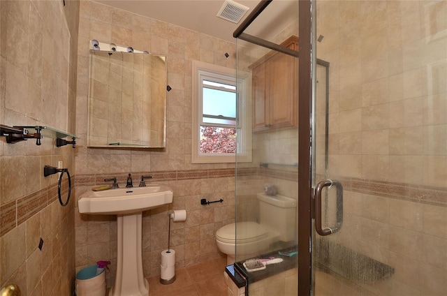 1793 Brian Ct, South Merrick, NY 11566 - bathroom with tile walls, a shower stall, toilet, tile patterned floors, and a sink