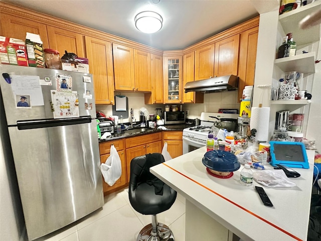 kitchen with appliances with stainless steel finishes, under cabinet range hood, a sink, light tile patterned flooring, and open shelves