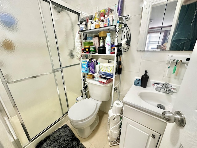 full bathroom featuring a stall shower, toilet, vanity, tile patterned floors, and tile walls